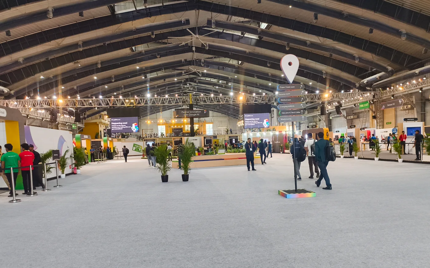 Visitors walking between demonstration booths in a large Google developer-event hall.